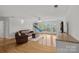 Expansive living room with hardwood floors, sliding doors, and cozy leather sofas offers bright, comfortable living at 3506 Cardiff Ln, Matthews, NC 28104