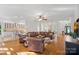 Open-concept living area with hardwood floors flowing into the kitchen and dining area, with a large leather sectional at 3506 Cardiff Ln, Matthews, NC 28104