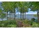 Picturesque backyard with mature trees and a scenic path leading to the serene lake at 392 Stonemarker Rd, Mooresville, NC 28117