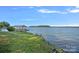 Scenic view of a private boat dock and covered slip, with a lush green lawn leading to the tranquil lake at 392 Stonemarker Rd, Mooresville, NC 28117