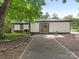 Exterior view of the home with a sliding glass door, landscaping, and patio at 406 Wilcrest Dr, Matthews, NC 28105