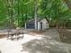 Detached garage and seating area with landscaping in a lush, wooded backyard at 406 Wilcrest Dr, Matthews, NC 28105