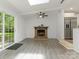 Bright living room featuring a brick fireplace, modern ceiling fan, and sliding glass doors for natural light at 406 Wilcrest Dr, Matthews, NC 28105