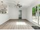 Bright living room featuring white walls, modern ceiling fan, and sliding glass doors for natural light at 406 Wilcrest Dr, Matthews, NC 28105