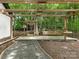 Outdoor pergola with seating area, landscaping, and a wooded backdrop at 406 Wilcrest Dr, Matthews, NC 28105