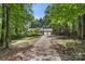 Brick home with a two-car garage is surrounded by lush greenery and trees at 410 Glass Ct, Kannapolis, NC 28081