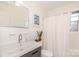 Cozy bathroom with modern sink, neutral paint, and a shower with white shower curtain at 4329 Hathaway St # D, Charlotte, NC 28211