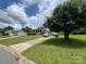 Beautiful home with well-manicured lawn and a two-car detached garage on a sunny day at 4414 Birkdale Dr, Charlotte, NC 28208