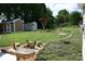 Expansive backyard featuring lush grass, decorative landscaping, and multiple storage sheds at 4711 Lenox Hill Pl # 98, Charlotte, NC 28269