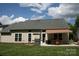 Back of house with a covered patio, grill, manicured lawn and cactus garden at 4711 Lenox Hill Pl # 98, Charlotte, NC 28269