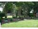 Nicely landscaped backyard featuring mature trees, lawn and decorative features at 4711 Lenox Hill Pl # 98, Charlotte, NC 28269