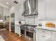 Gourmet kitchen boasts a stainless steel range hood over the oven, white cabinets, and granite countertops at 5030 Waldron Meadow Dr, Charlotte, NC 28226