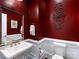 Chic half bathroom with red walls, pedestal sink, and decorative mirror at 5030 Waldron Meadow Dr, Charlotte, NC 28226