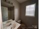 Bathroom with a single sink vanity, neutral walls, and a window for natural light at 5523 Stone Bluff Ct, Charlotte, NC 28214