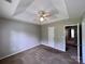 Bedroom features a tray ceiling, neutral walls, a ceiling fan, and natural light at 5523 Stone Bluff Ct, Charlotte, NC 28214