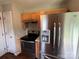 Galley kitchen featuring stainless steel refrigerator and wood cabinets at 5523 Stone Bluff Ct, Charlotte, NC 28214