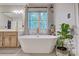Elegant bathroom with a freestanding tub, garden views, and a marble-topped vanity at 5611 Charter Oaks Ln, York, SC 29745