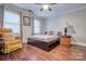 Bedroom with a wooden bedframe, hardwood floors, natural light, and an accent chair at 5611 Charter Oaks Ln, York, SC 29745