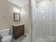 Bathroom featuring a single sink vanity and walk-in shower with vertical subway tile at 6017 Sierra Dr, Charlotte, NC 28216