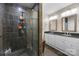 Modern bathroom featuring a tiled shower and double sink vanity with white cabinets and elegant lighting at 6017 Sierra Dr, Charlotte, NC 28216
