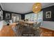 Bright dining room with hardwood floors, large windows, modern lighting, and elegant staging at 6017 Sierra Dr, Charlotte, NC 28216