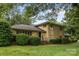 Traditional two-story brick home featuring mature trees, manicured shrubs and well-maintained lawn at 6017 Sierra Dr, Charlotte, NC 28216