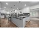 Bright, modern kitchen with white cabinetry, stainless steel appliances, and a large central island at 6017 Sierra Dr, Charlotte, NC 28216