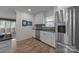 Well-lit kitchen featuring white cabinets, stainless steel appliances and wood-look flooring at 6017 Sierra Dr, Charlotte, NC 28216
