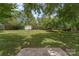 A spacious backyard featuring a storage shed and mature trees providing shade at 613 Poplar Dr, Shelby, NC 28152