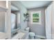 Well-lit bathroom with a granite vanity, decorative mirror, and a window offering natural light at 613 Poplar Dr, Shelby, NC 28152