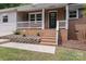 Inviting front porch with brick steps, landscaping, and charming details at 613 Poplar Dr, Shelby, NC 28152