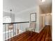Second floor hallway featuring hardwood floors, a tufted chair, and a view of the foyer at 701 Larkridge Ct, Rock Hill, SC 29730