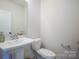 Clean powder room featuring a pedestal sink and a standard toilet at 711 Beaty St, Davidson, NC 28036