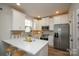 Modern kitchen with white cabinets, stainless steel appliances, quartz countertops and a breakfast bar at 711 Beaty St, Davidson, NC 28036