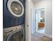 Convenient laundry area with stacked washer and dryer, leading to a bright room with a desk at 711 Beaty St, Davidson, NC 28036