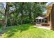 Lush backyard showcasing a patio with outdoor seating, privacy landscaping, and a brick house at 7211 Baniff Cir, Charlotte, NC 28277