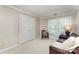 Bedroom with a chair and sofa by the window and a closed door at 7211 Baniff Cir, Charlotte, NC 28277