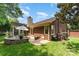 Charming brick home featuring a patio with an umbrella and view of the backyard at 7211 Baniff Cir, Charlotte, NC 28277