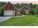 Charming brick home with manicured lawn and landscaping, plus a two-car garage and inviting walkway at 7211 Baniff Cir, Charlotte, NC 28277