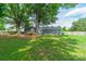 Large fenced-in backyard with mature trees, wood deck and patio furniture, and new gray siding at 7901 Reames Rd, Charlotte, NC 28216