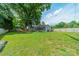 Expansive backyard featuring a lush lawn and a newly updated home with mature trees and green foliage at 7901 Reames Rd, Charlotte, NC 28216