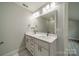 Bathroom featuring a double sink vanity with a large mirror and updated lighting fixtures at 7901 Reames Rd, Charlotte, NC 28216
