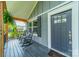 Covered front porch with rocking chairs, hanging plants, and a gray front door at 7901 Reames Rd, Charlotte, NC 28216