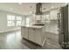 Modern kitchen with a center island, stainless steel range hood, and an abundance of natural light at 7901 Reames Rd, Charlotte, NC 28216