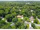 An aerial view showcases this charming single-Gathering home nestled among mature trees with a well-manicured lawn at 7916 Wellston Dr, Charlotte, NC 28210
