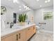 Bright bathroom featuring a double sink vanity with light wood cabinets and gray tile flooring at 7916 Wellston Dr, Charlotte, NC 28210