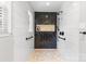 Modern tiled shower featuring black herringbone tile accent wall, marble floors, and glass door at 7916 Wellston Dr, Charlotte, NC 28210