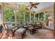 Relaxing screened sunroom featuring wicker furniture, a ceiling fan, and views of backyard trees at 7916 Wellston Dr, Charlotte, NC 28210