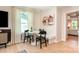 Cozy dining area with natural light, seating, and artwork, next to tv, bench and doorway to bedroom at 7930 Rolling Wheels Rd, Charlotte, NC 28215