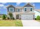 Charming two-story home featuring gray siding, a two-car garage, and a well-maintained front lawn at 7930 Rolling Wheels Rd, Charlotte, NC 28215